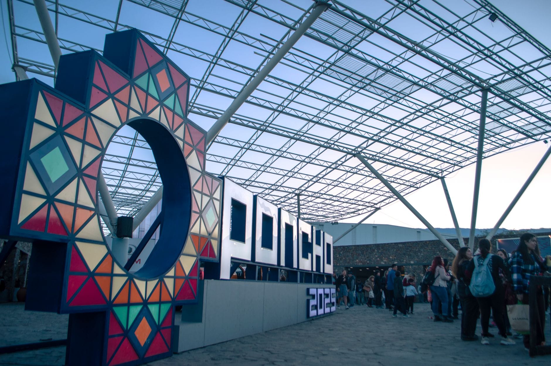 Uczestnicy targów na hali expo wśród kolorowych neonowych szyldów